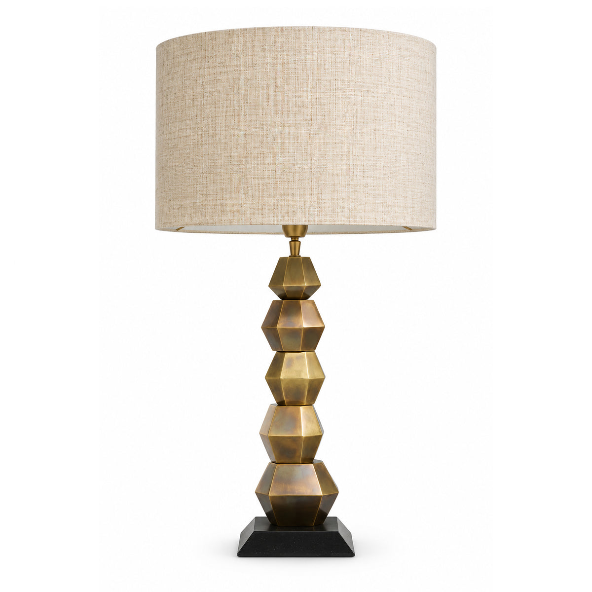 A luxurious Eichholtz Lior table lamp featuring a sculptural vintage brass base, glowing warmly on a high-end console table at the Eichholtz Los Angeles showroom